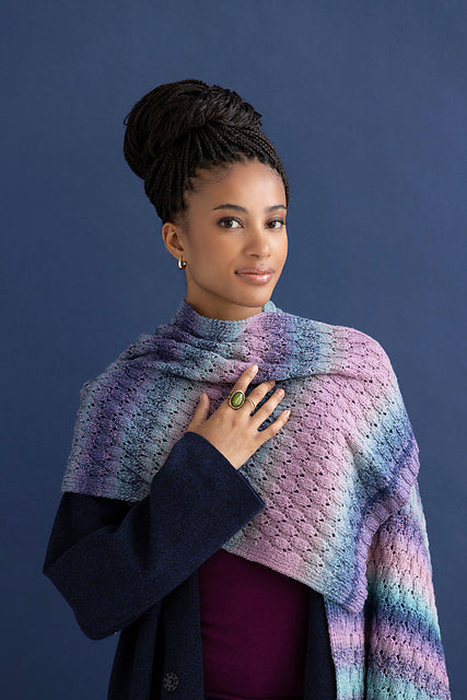 Woman wearing the Adalynn Scarf draped over one shoulder, knit in Ella Rae Color Magic Pretty in Pink (510)